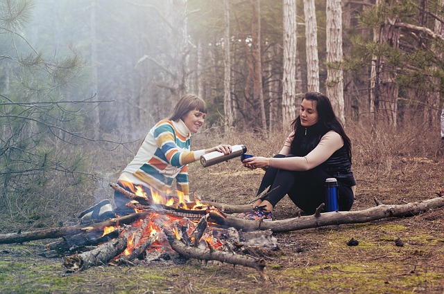 森の中で焚き火をする2人の女性