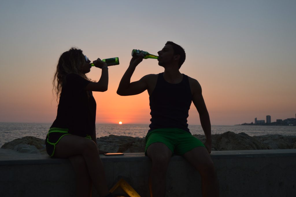 外で飲み物をのむ男女