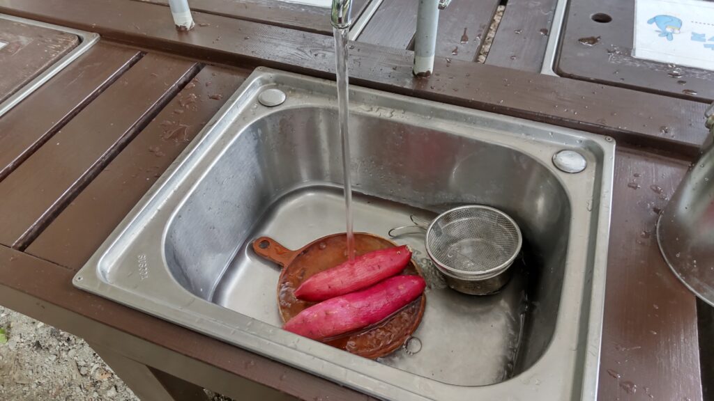 サツマイモを水で洗う
