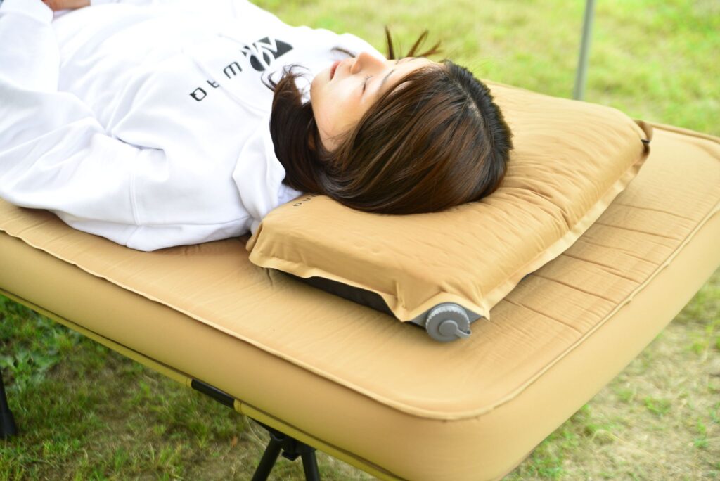 キャンプ用枕で寝る女性