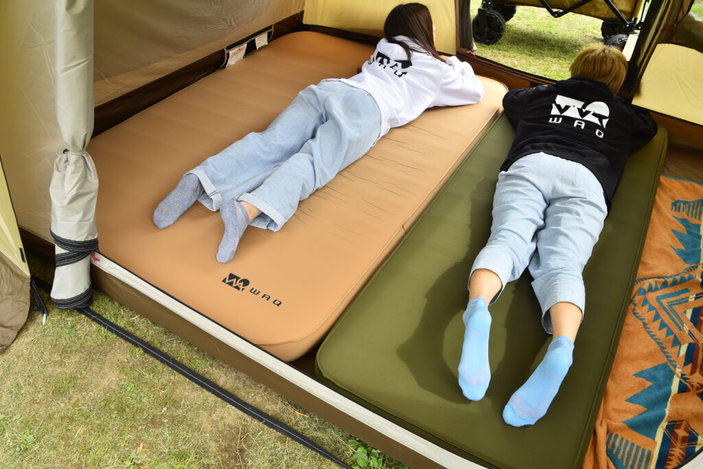 WAQ RELAXING CAMP MAT シングルサイズとダブルサイズを2つ並べて寝転ぶ女性2人