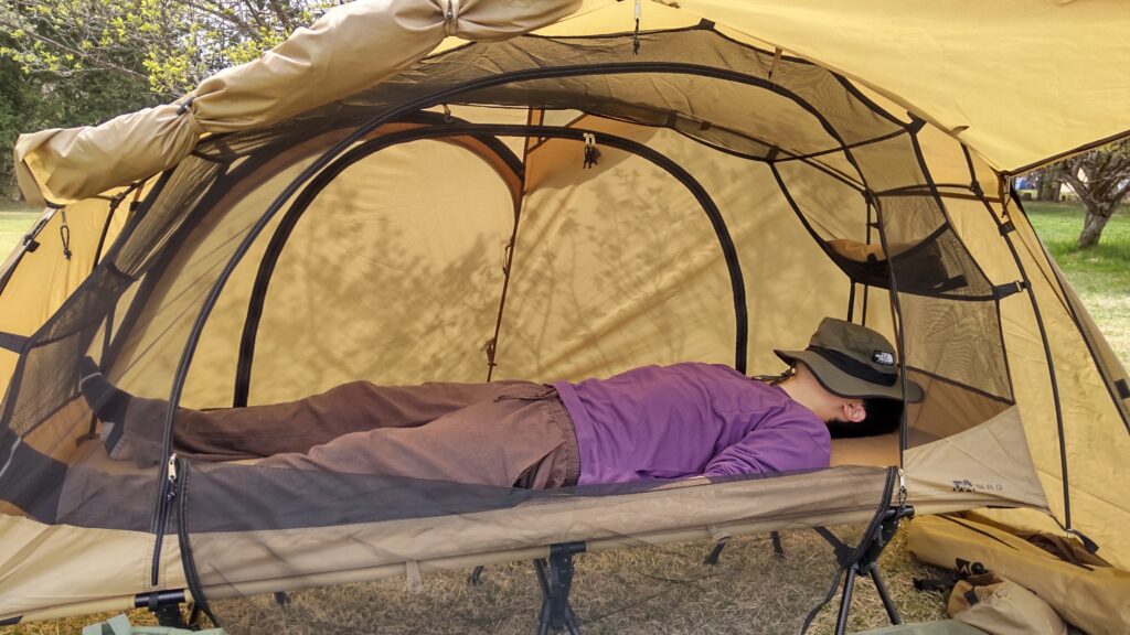 WAQ ASTRA CT 2WAYコット専用テントの中で寝る男性